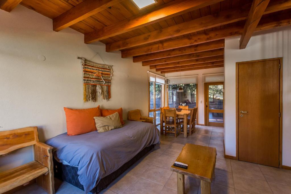 ein Schlafzimmer mit einem Bett und einem Tisch in einem Zimmer in der Unterkunft Balcones del Sayhueque in Villa La Angostura