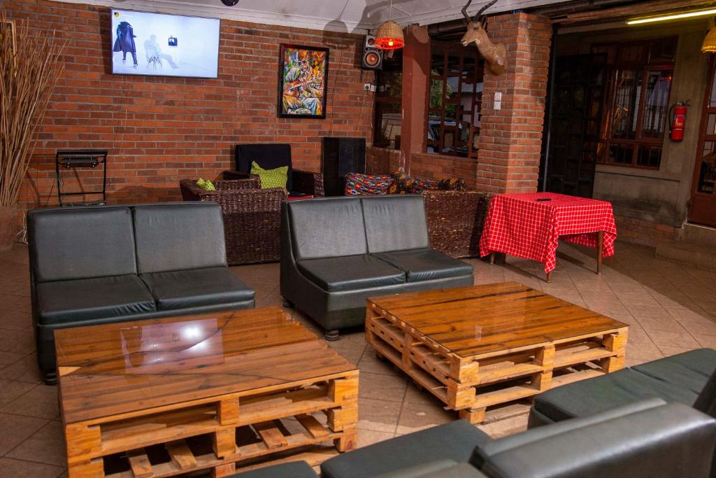 a restaurant with couches and tables and a tv at Meru Hostel in Arusha