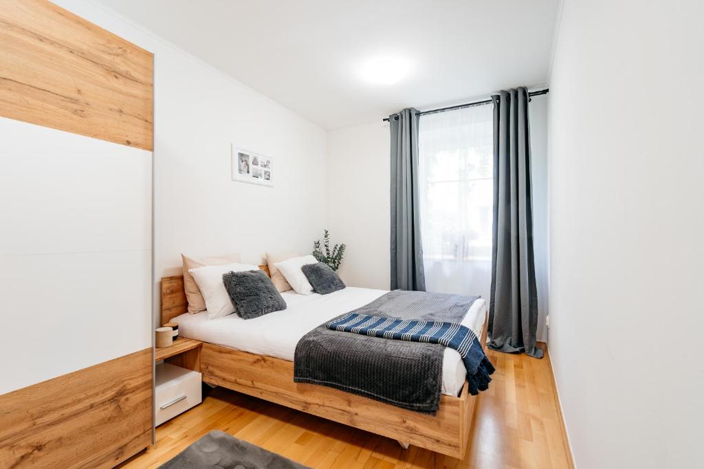 een slaapkamer met een bed en een raam bij Cosy Apartment by LoftAffair in Krakau