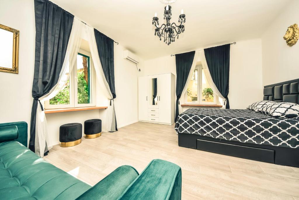 een slaapkamer met een bed, een bank en ramen bij Luxury Heritage Apartment Zara Antica in Zadar