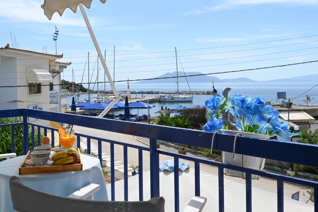 a table on a balcony with a view of the ocean at Hotel Avra in Néa Epídhavros