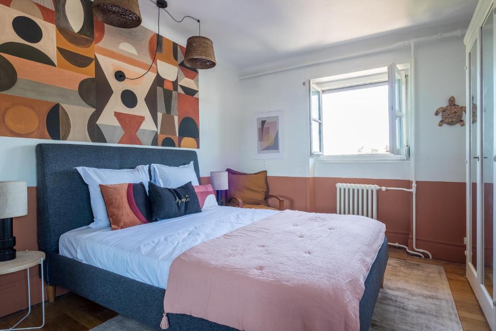 une chambre avec un lit avec un tableau sur le mur dans l'établissement HONORÊ SUITE CASAMANCE, à Lyon