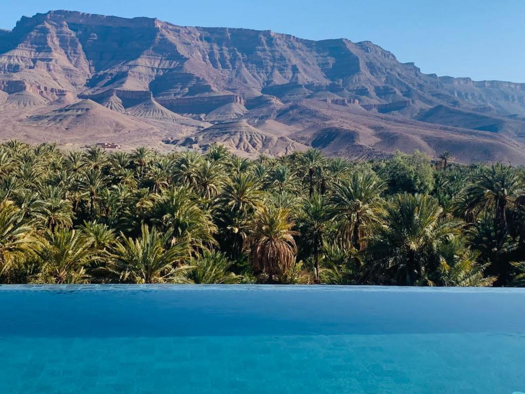 a view of the desert mountains and a blue lake at Kasbah Hnini in Igdourane