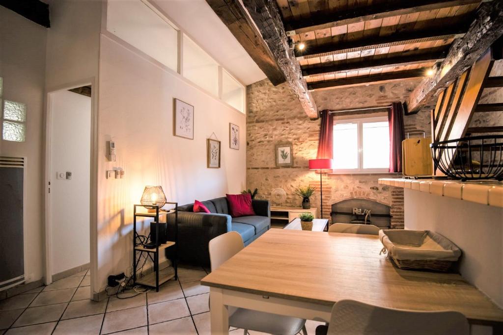 Bel appartement cosy au coeur de Cabestany في Cabestany: غرفة معيشة مع طاولة خشبية كبيرة في غرفة