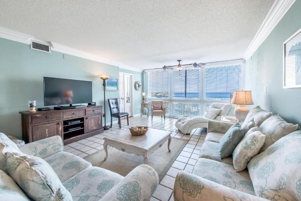 a living room with a couch and a tv at Shoreline Towers 3074 in Destin