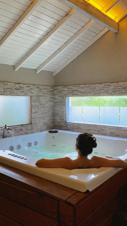 a woman laying in a bath tub in a room at Atelier Hotel Charme & Spa in Villa General Belgrano