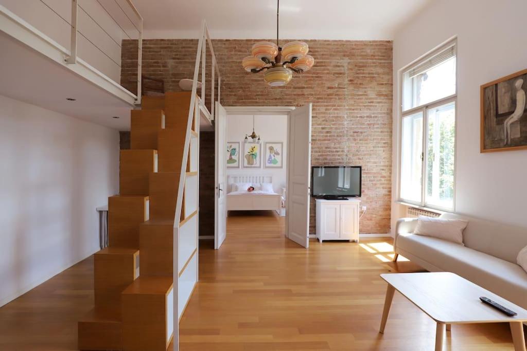 een woonkamer met een trap en een bank bij Apartment Piano Nobile, Zagreb in Zagreb
