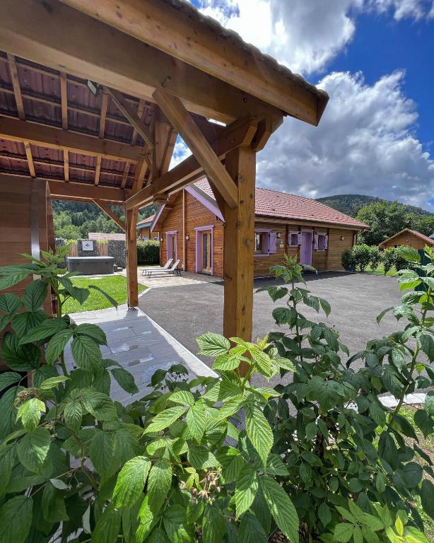 uma pérgola de madeira em frente a um edifício em Chalet Le Familial - SPA & SAUNA - Serviettes - Peignoirs - Lits faits - Ménage inclus em Rochesson