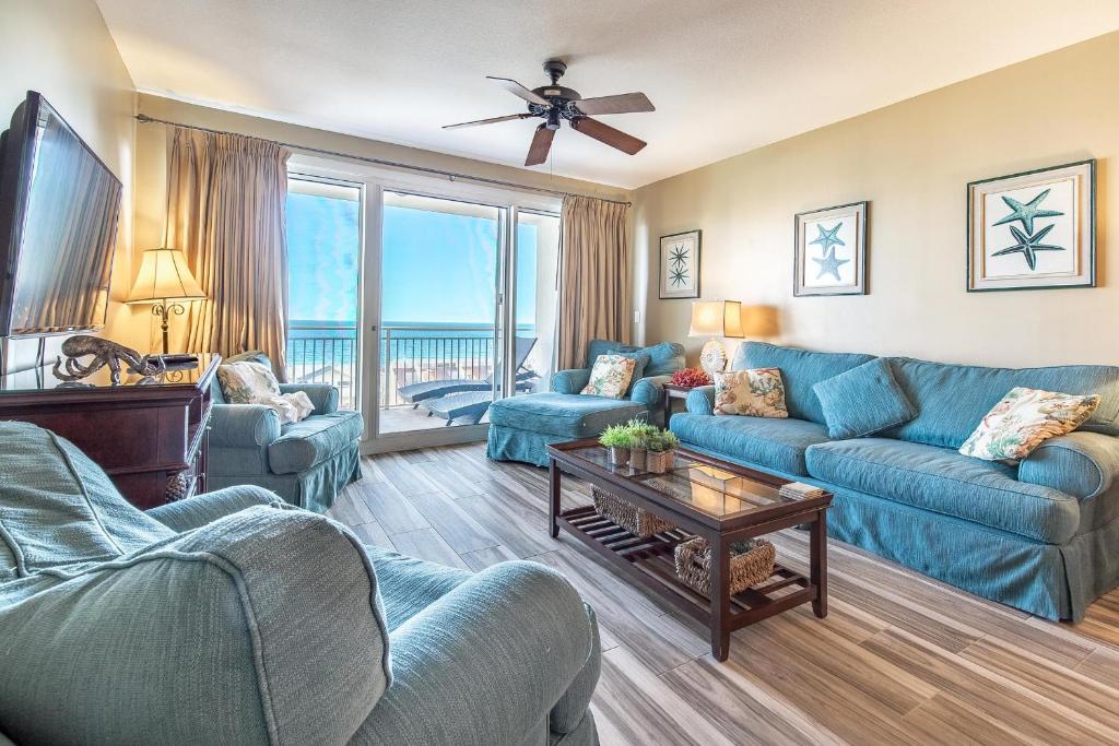 a living room with blue furniture and a view of the ocean at Sterling Shores 818 in Destin