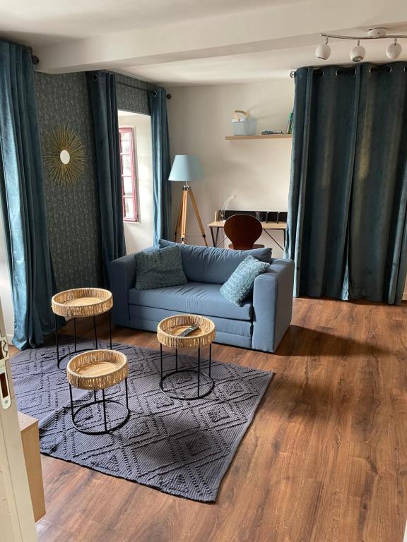 a living room with a blue couch and two tables at LouSangla in Salies-de-Béarn