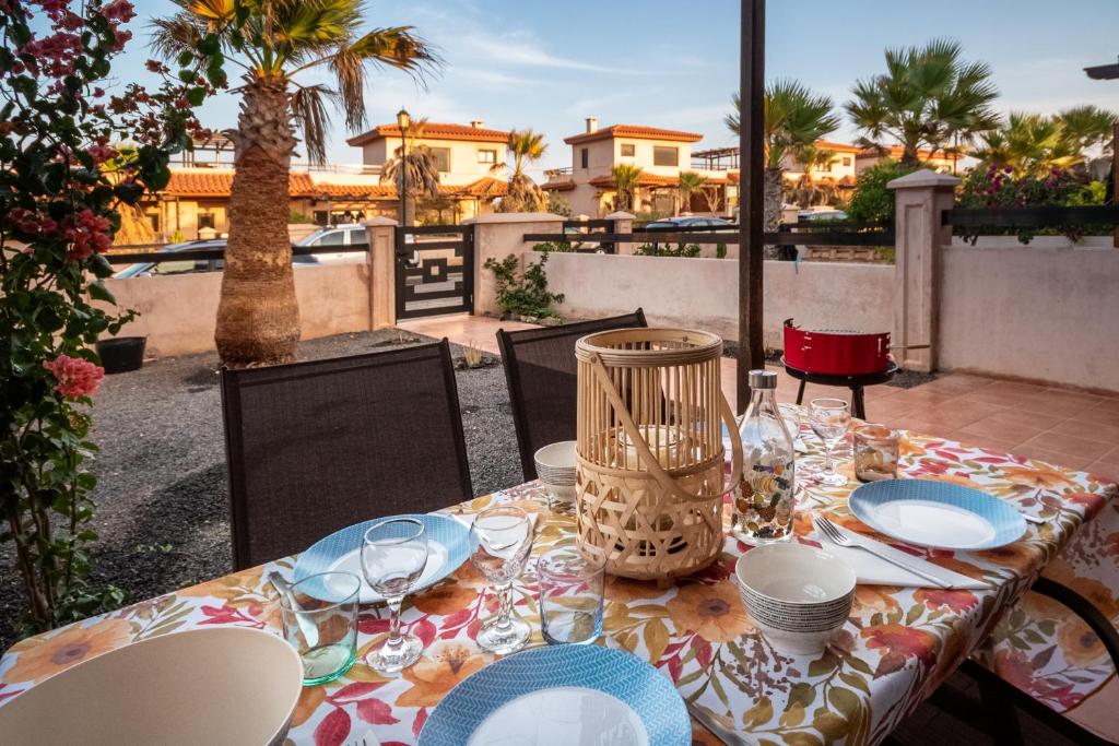 een tafel met borden en glazen op een patio bij Casa Belle - Origomare - Lajares - Majanicho in Lajares