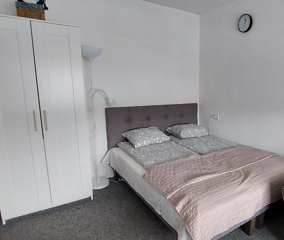 um quarto com uma cama e um armário branco em Dzīvoklis 17 em Rūjiena