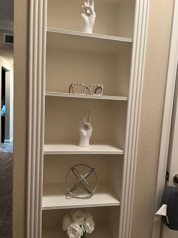 a closet with two glasses and a pair of hands on shelves at Smoke free Amazing spacious 2 beds 2 baths modern living in Houston