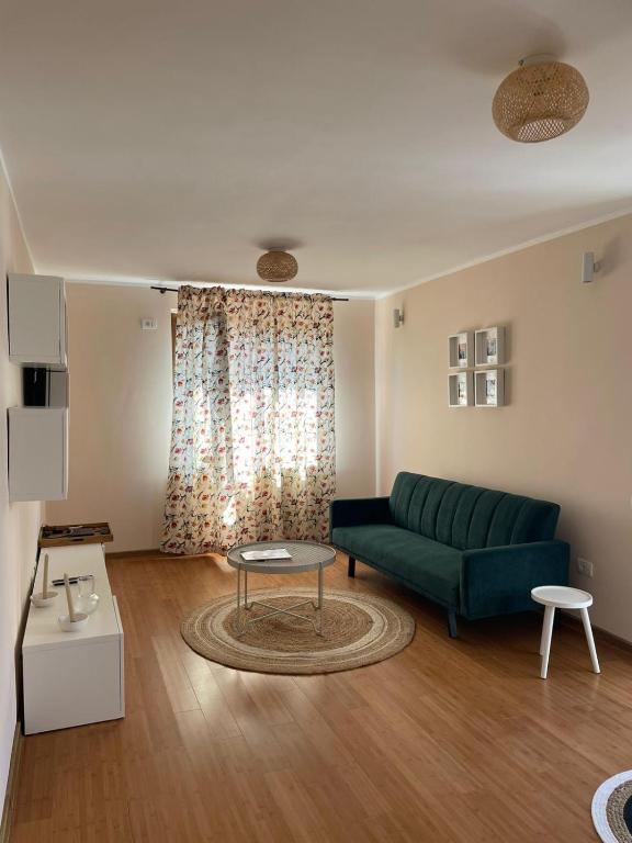 a living room with a green couch and a table at Cozy Apartment Old Town in Constanţa