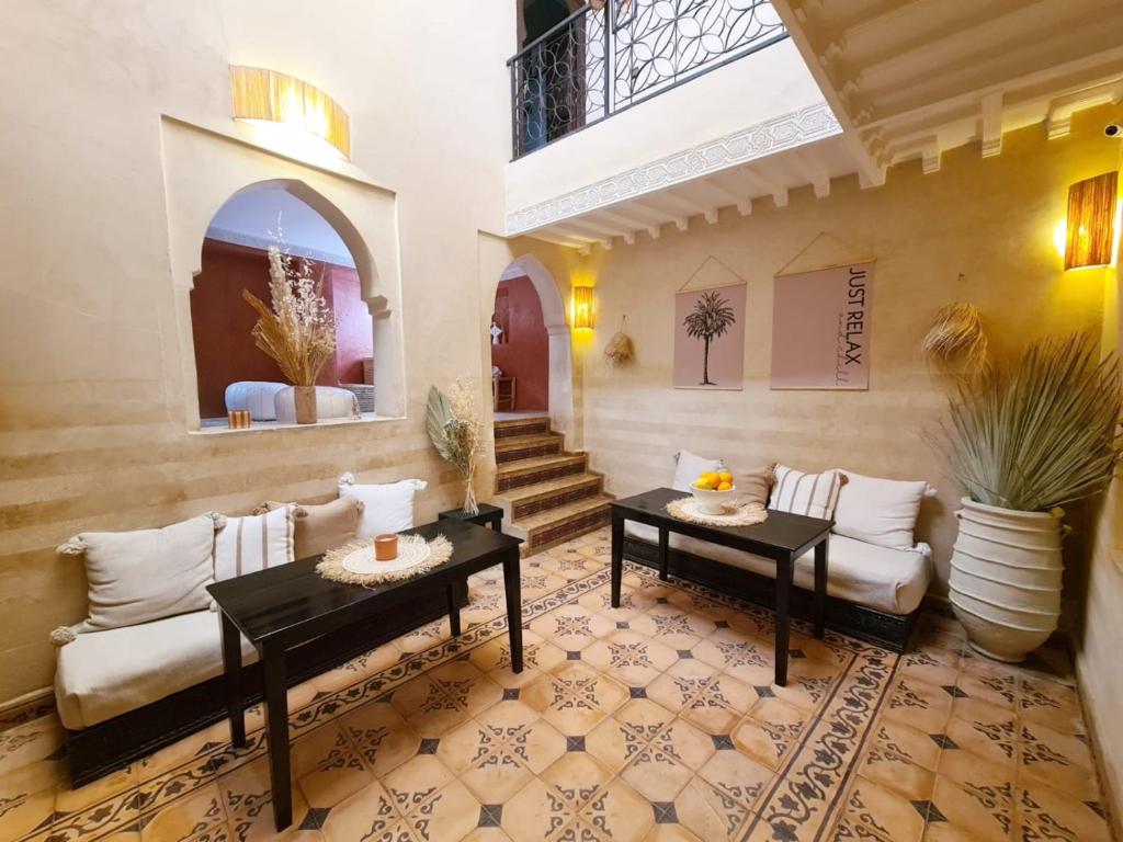 ein Wohnzimmer mit einer Couch und zwei Tischen in der Unterkunft Riad Casa Sophia in Marrakesch