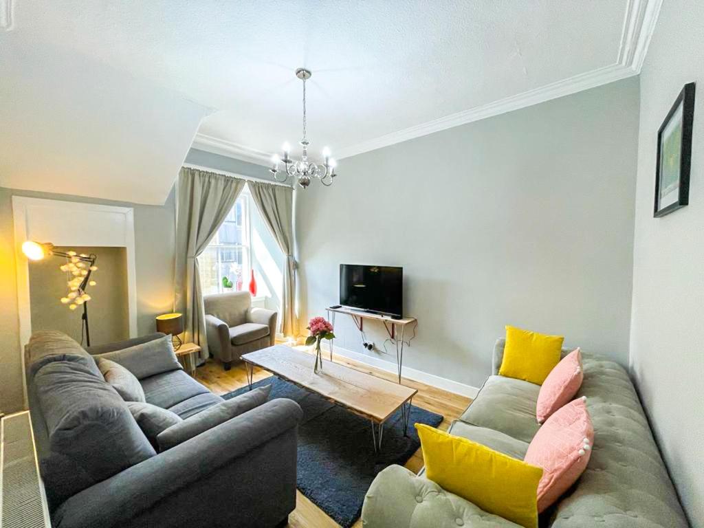 a living room with two couches and a table at Charming 3 Bed Apartment in Old Town in Edinburgh