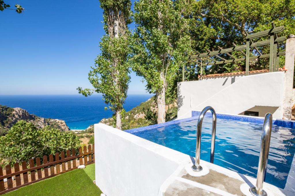 a swimming pool with a view of the ocean at Mertonas Villa in Karpathos