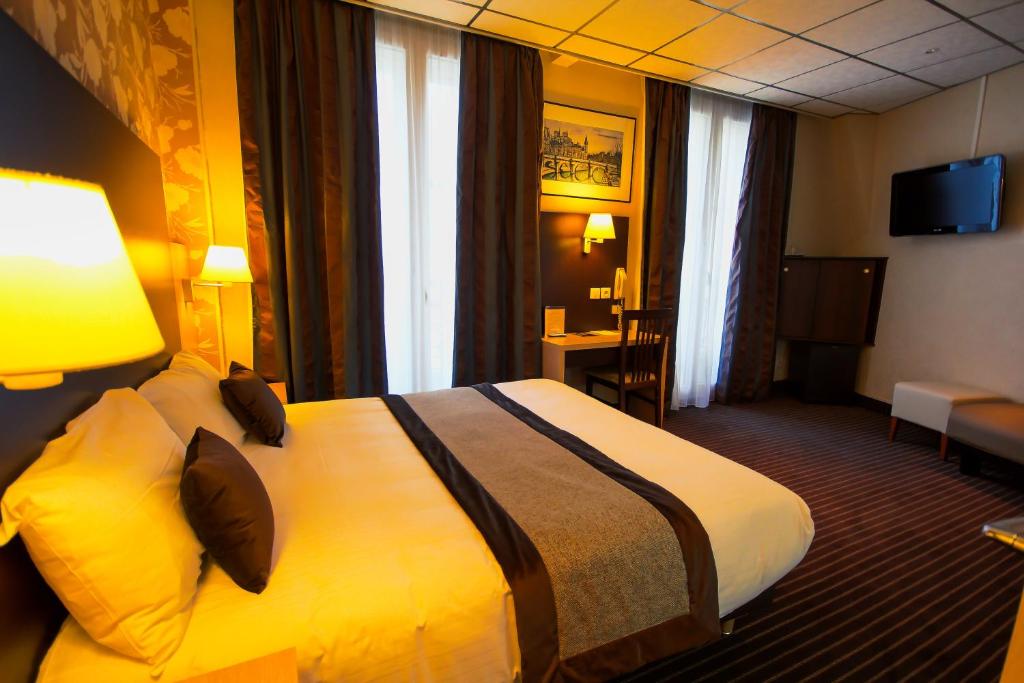 ein Hotelzimmer mit einem großen Bett in einem Zimmer in der Unterkunft Hôtel Des Trois Gares in Paris