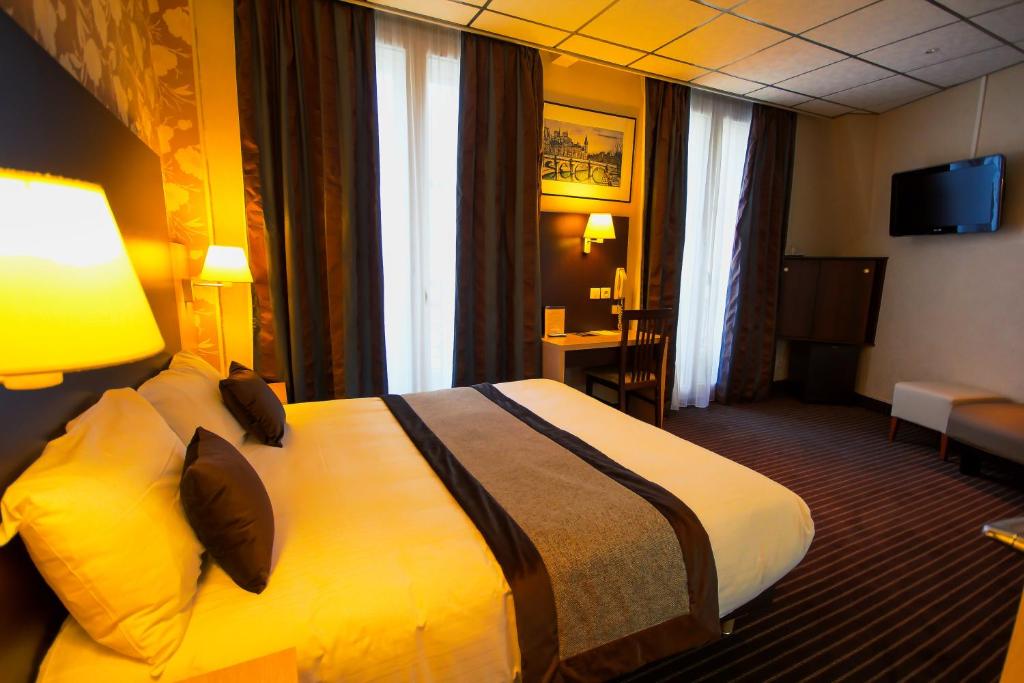 Una habitación de hotel con una cama grande en una habitación. en Hôtel Des Trois Gares, en París