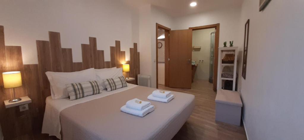 アルジェズールにあるCasa Bárbara - No centro histórico de Aljezurのベッドルーム1室(大きな白いベッド1台、タオル付)