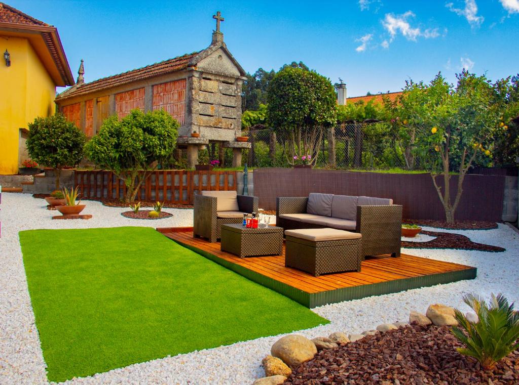 a garden with a couch and chairs and grass at A Casa de Carballo in Meis
