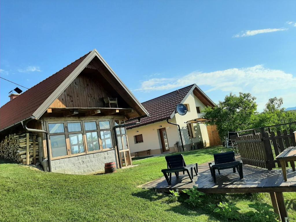 ein Haus mit zwei Stühlen und einem Tisch im Hof in der Unterkunft Holiday house Aronija in Šmarje pri Jelšah