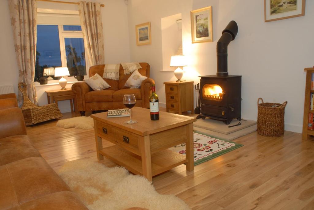 a living room with a wood stove in a living room at Coolbeg Farmhouse in Maguires Bridge