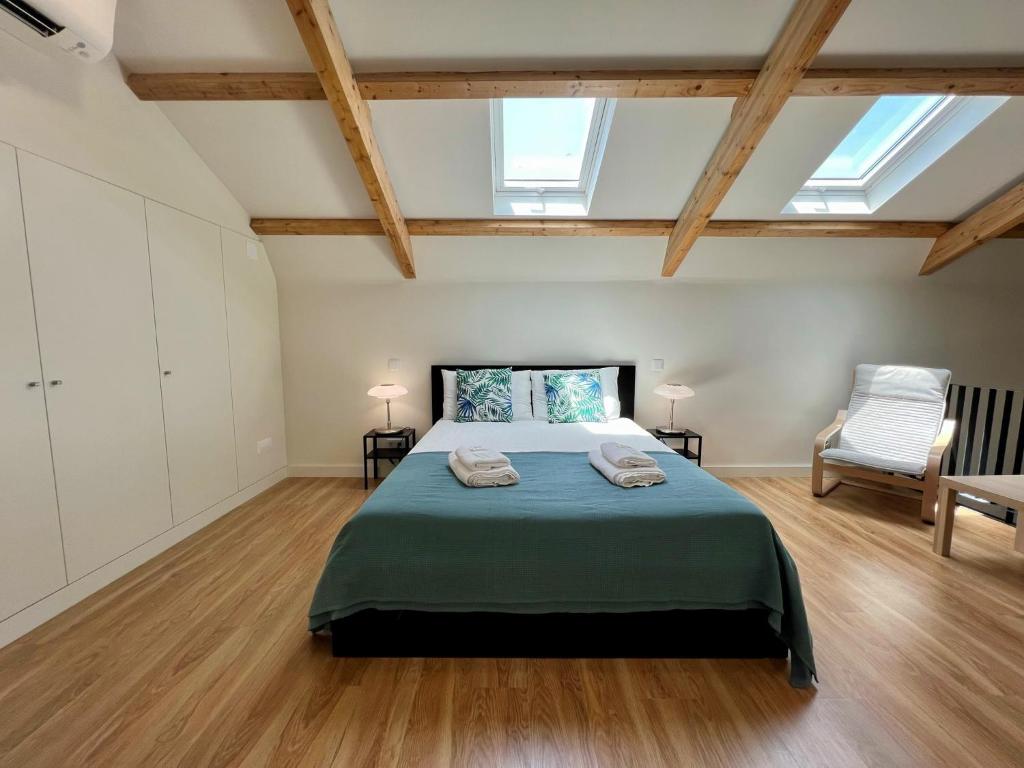 a large bedroom with a bed and a chair at Faro Design 7 by Homing in Faro