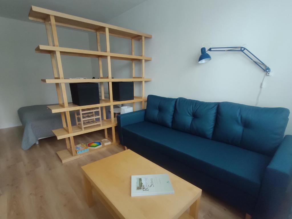 a living room with a blue couch and a coffee table at Útulný bytík iba 5 minút od historického centra in Rimavská Sobota