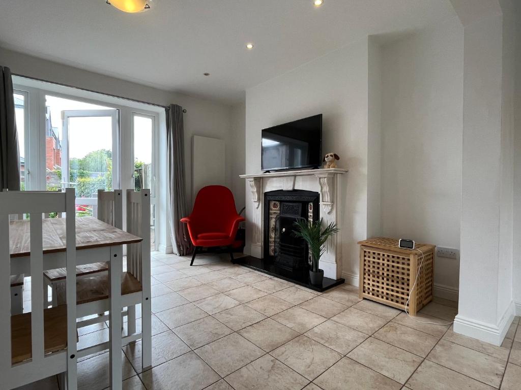 uma sala de estar com lareira e uma cadeira vermelha em Sandymount House & Garden em Dublin