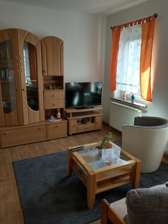 sala de estar con TV y mesa de centro en Ferienwohnung im Erzgebirge in Gelenau, en Gelenau