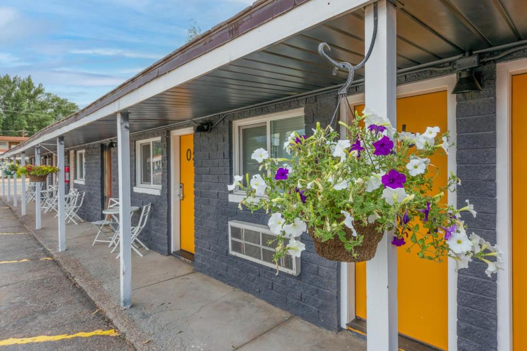 a building with a hanging basket of flowers at Minecart Motor Lodge in Montrose