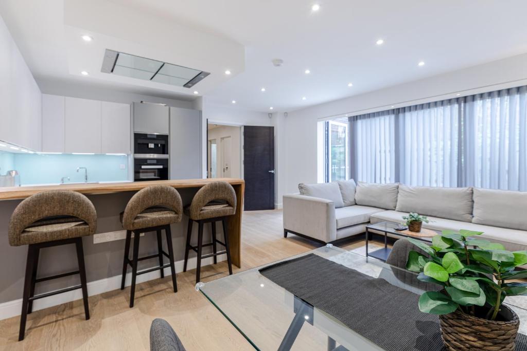 cocina y sala de estar con sofá y mesa en StayInn Aldgate, en Londres