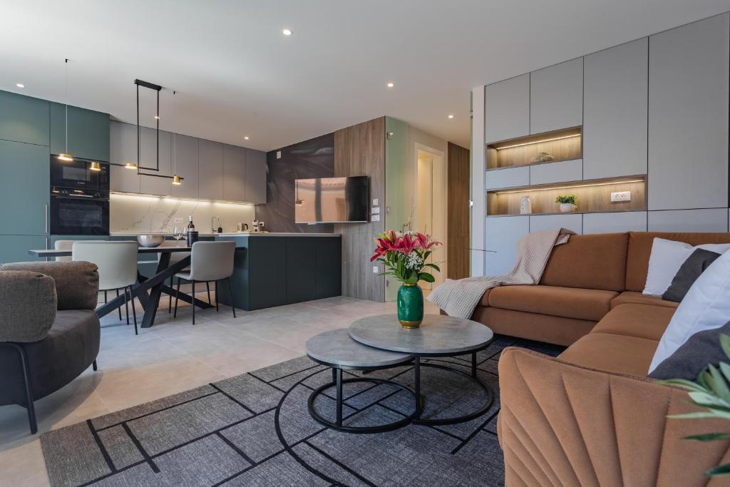a living room and kitchen with a couch and a table at Petit Palace in Zadar