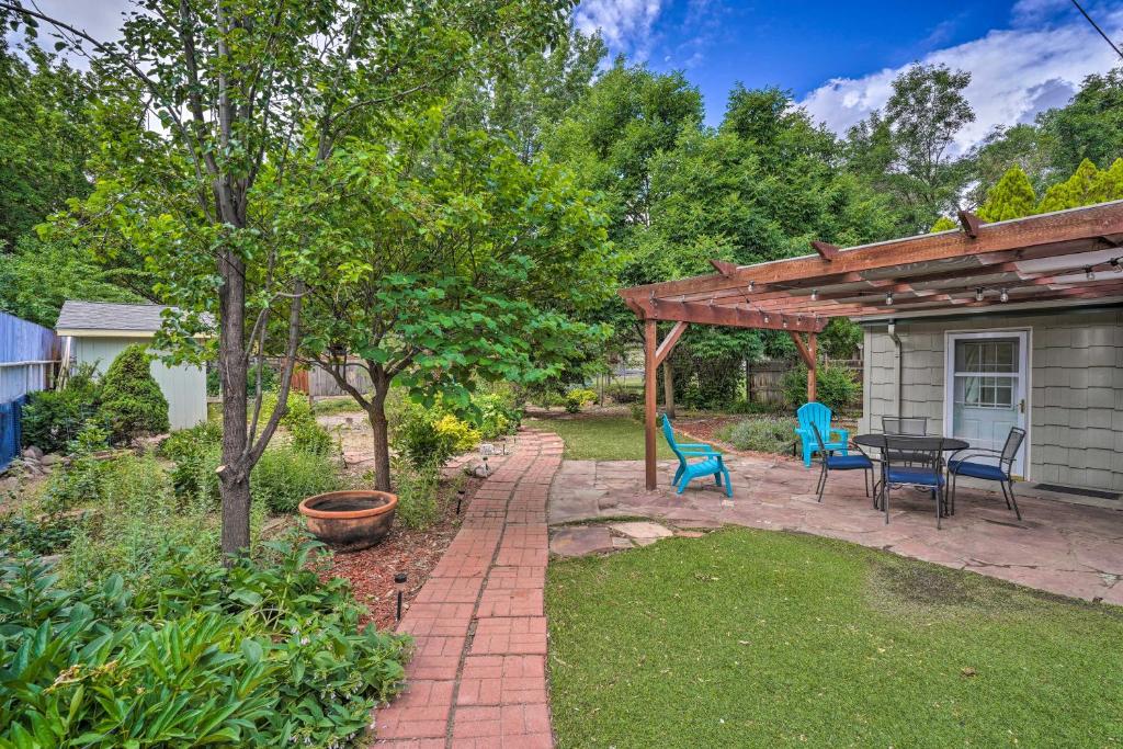 een patio met een tafel en stoelen en een houten pergola bij Cañon City Casa with Spacious, Private Yard! in Canon City