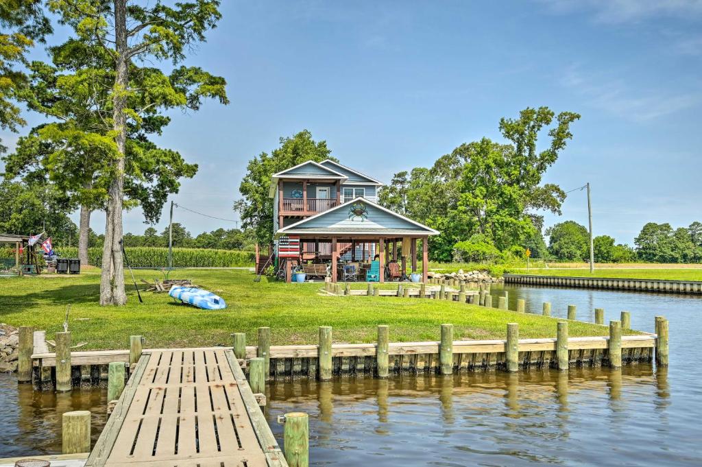 uma casa na margem de um lago com uma doca em Prized Riverfront Condo with Fishing On-Site! em Belhaven