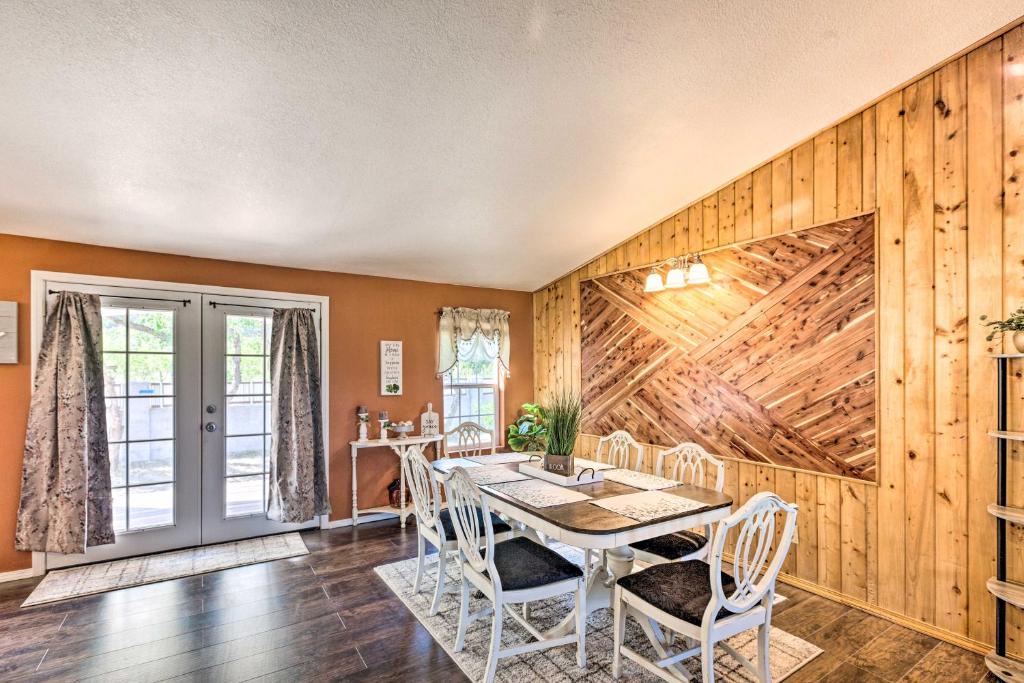 una sala da pranzo con tavolo, sedie e pareti in legno di Peaceful Vadito Family Home Near Taos Valley! 