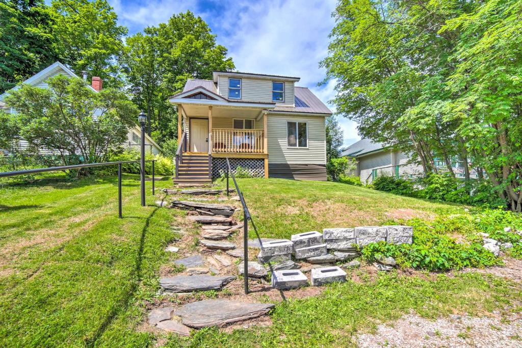 a house on a hill with a stone path in front of it at Cozy Ishpeming Cottage with Lake and Park Views! in Ishpeming