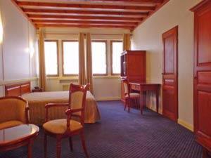 Cette chambre comprend un lit, une table et des chaises. dans l'établissement Hôtel Losset, à Flagey-Échézeaux