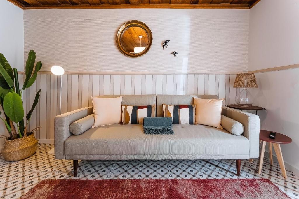 um sofá numa sala de estar com um espelho em Casa Amarela em Óbidos