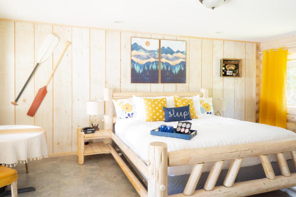a bedroom with a wooden bed with pillows on it at Log Inn Bonners Ferry in Bonners Ferry