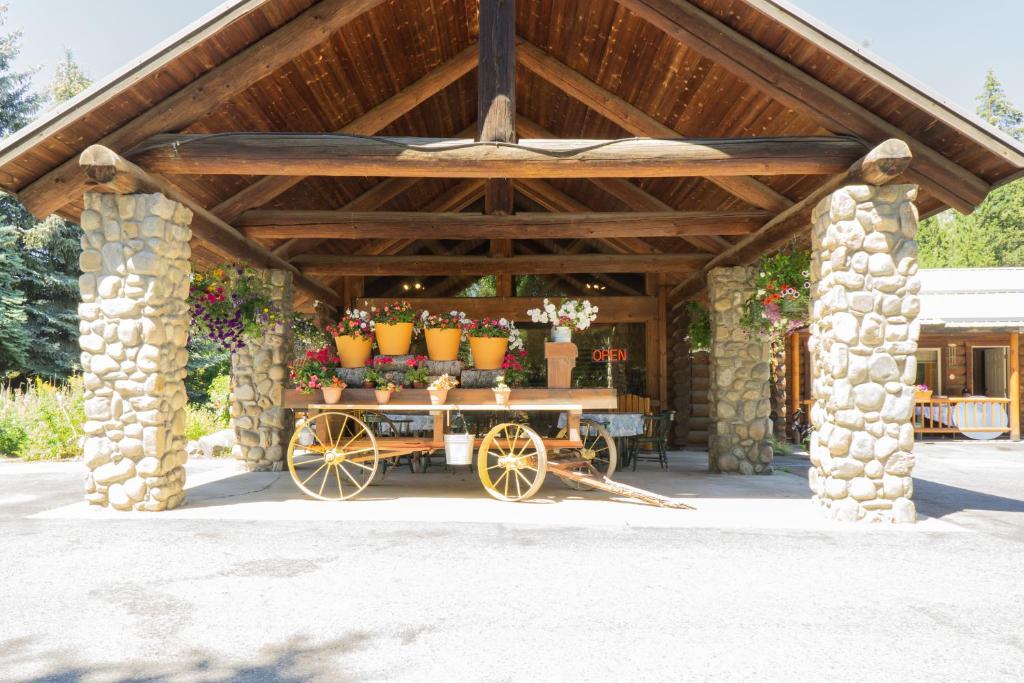 a wooden pavilion with a cart with vases on it at Log Inn Bonners Ferry in Bonners Ferry