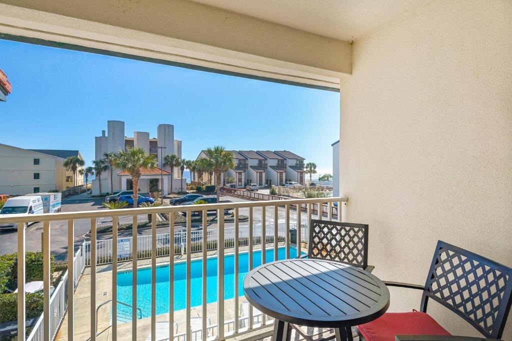 a balcony with a table and chairs and a pool at Palm Grove at Sago Sands Unit A in Seagrove Beach