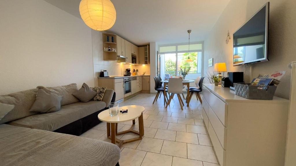 ein Wohnzimmer und eine Küche mit einem Sofa und einem Tisch in der Unterkunft Haus Dortmund - Ferienwohnung Nr.2 in Cuxhaven