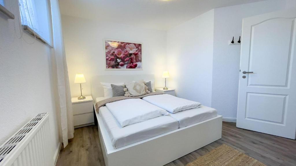 クックスハーフェンにあるStrandrobbe-7の白いベッドルーム(ベッド1台、ランプ2つ付)