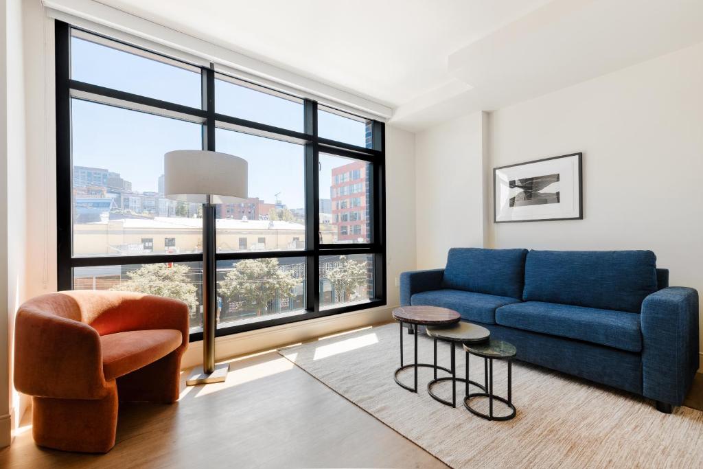 a living room with a blue couch and a large window at Sonder at Pivot in Seattle