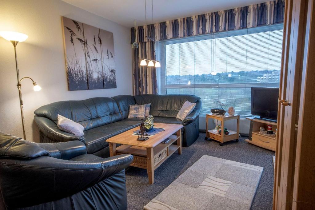 un salon avec un canapé et une télévision dans l'établissement Frische-Brise-03-04, à Cuxhaven