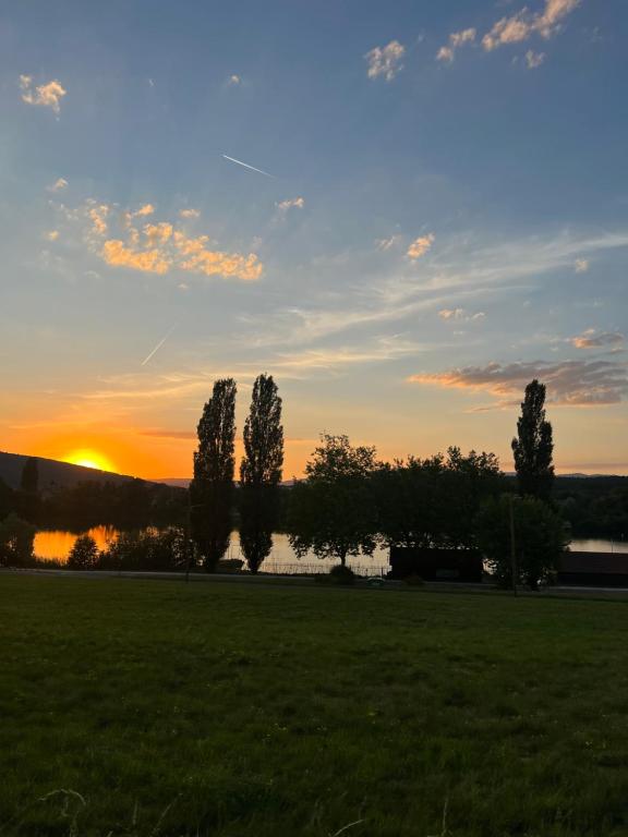 a sunset over a field with trees and a lake at Cocon Accès facile Parking Gratuit in Belfort