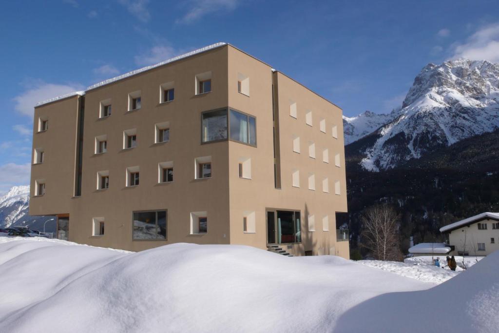 a large building with a snow covered roof at Scuol Youth Hostel in Scuol