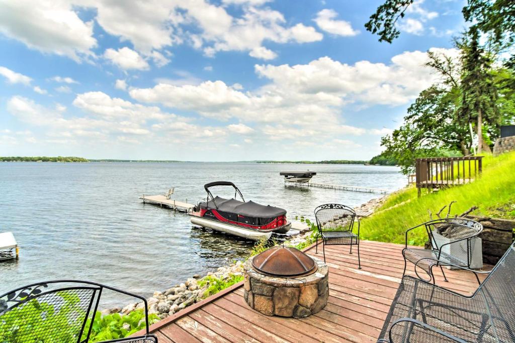 a wooden deck with a boat on the water at Family-Friendly Home on Pelican Lake with Fire Pit in Dunvilla